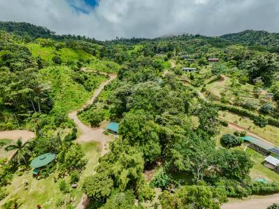 Finca autosuficiente en la montaña con cascada, río y varias parcelas.